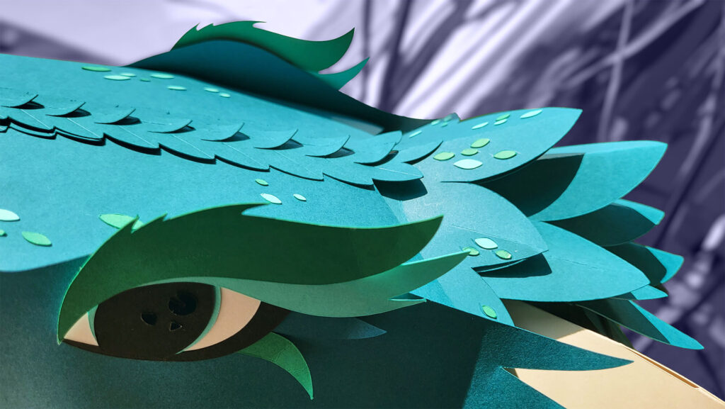 Référence d'Ylos : détail d'une tête de dragon en papier découpé
