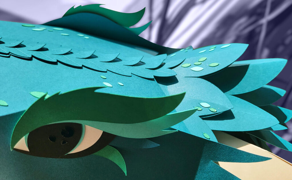 Référence d'Ylos : détail d'un masque de dragon en papier découpé